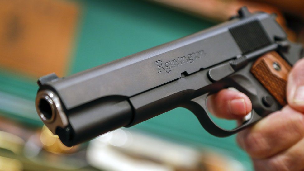 Prodavac u Atlanti drži pištolj Remington, februar 2018. godine