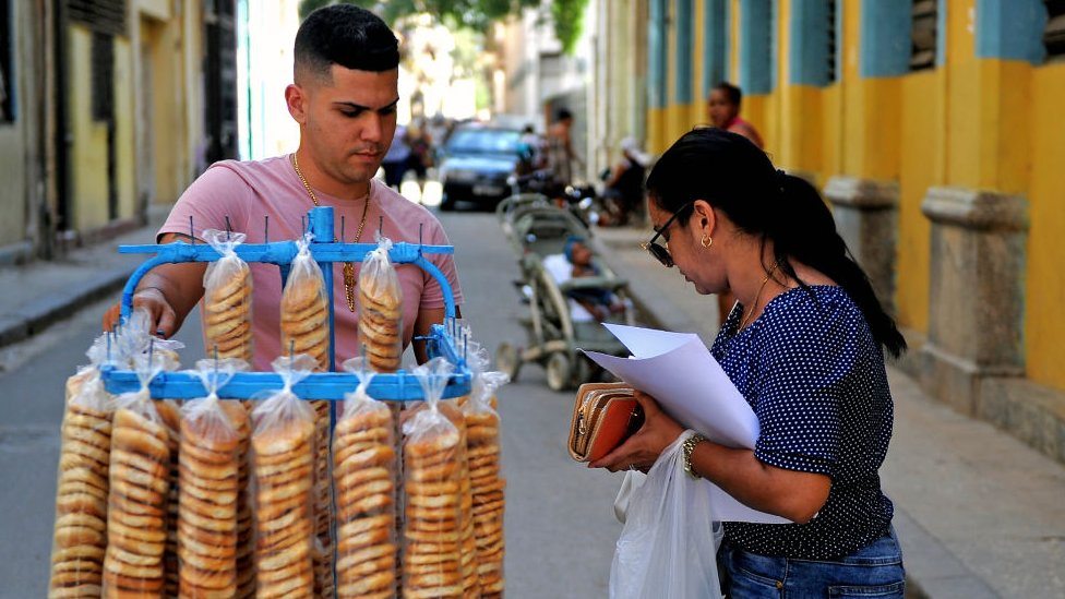 Žena kupuje od prodavca na ulicama Havane