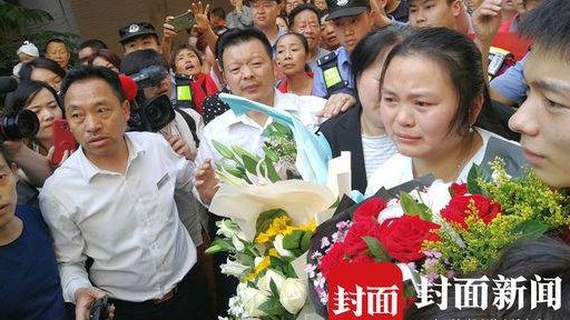 Kang Jing drži cveće, okružena porodicom
