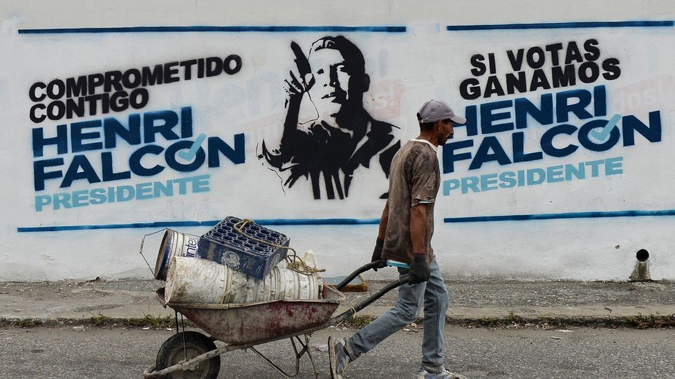 Radnik prolazi pored izborne propagande, Venecuela