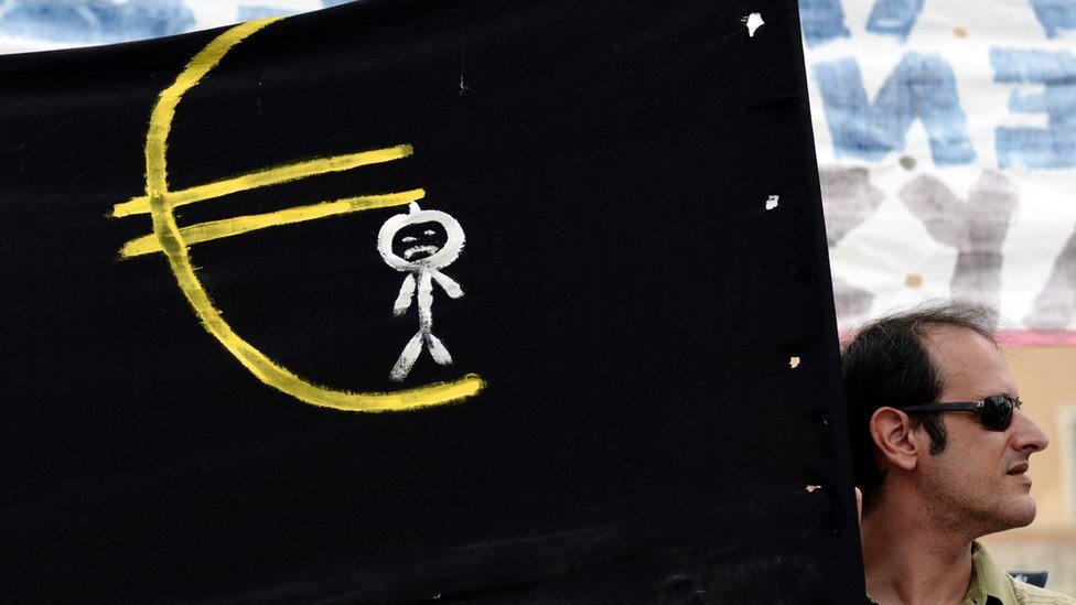 Anti-evropski demonstrant drži znak na kome se vidi čovek koji je obešen o evro.