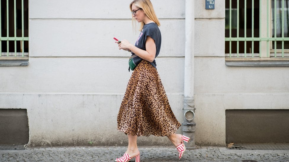 Devojka šeta i drži mobilni telefon