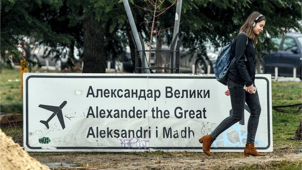 Žena prolazi pored uklonjenog znaka za aerodrom Aleksandar Veliki u Skoplju, 19. februar 2018