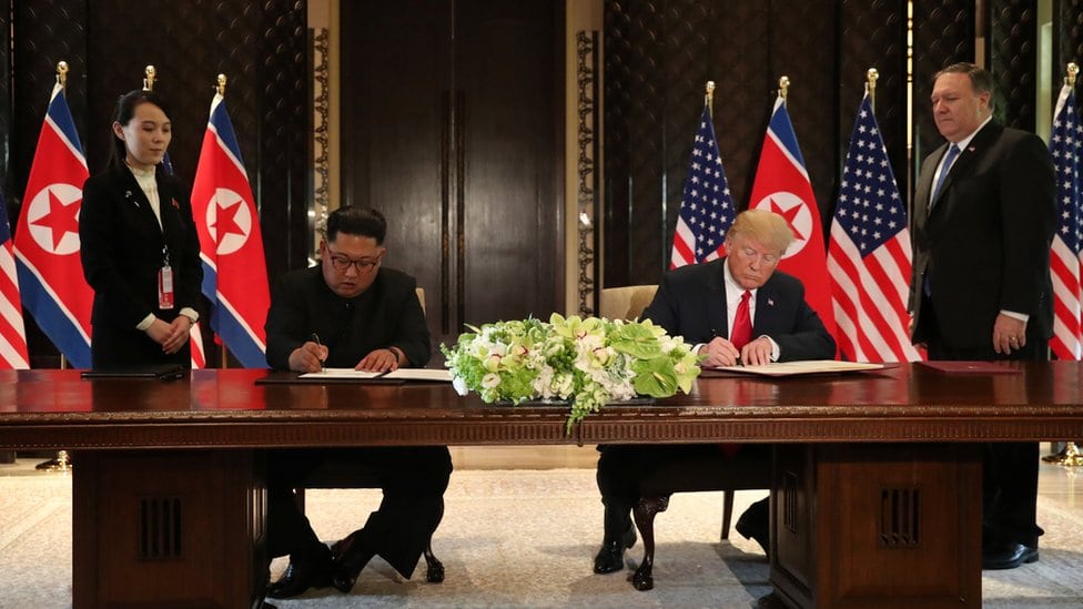 Predsednik SAD Donald Tramp i lider Severne Koreje Kim Džong-un potpisuju dokument