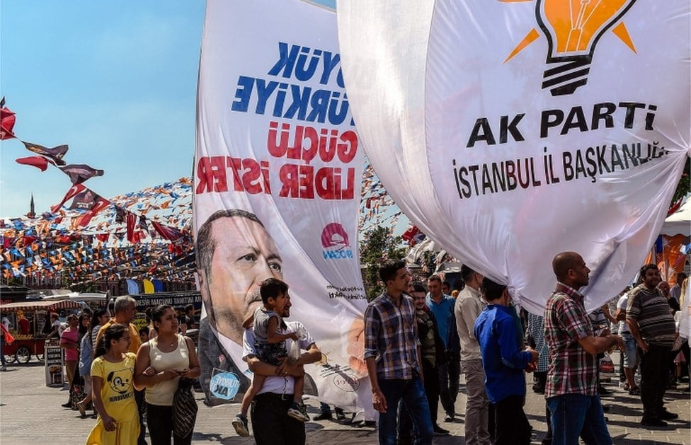 Ljudi nose izborne postere sa likom turskog predsednika i zastavama vladajuće AKP partije na mitingu u Istanbulu 14. juna 2018.