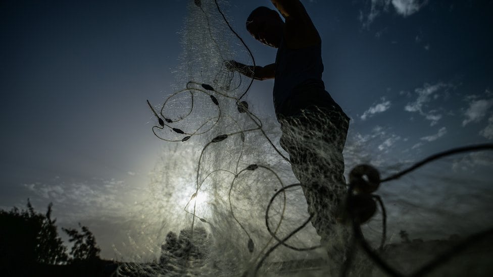 Ribar baca mrežu u suton