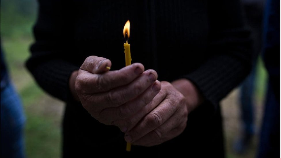 Srebrenica i Bratunac: Pomen za srpske žrtve ubijene na početku rata u Bosni 3 Žena drži sveću u rukama