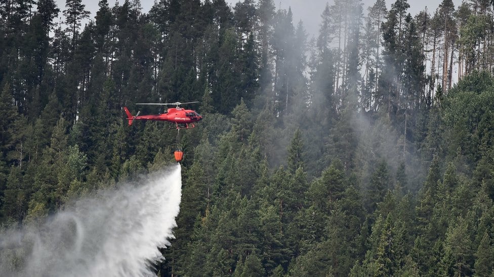 Helikopter spušta džak vode blizu sela Grotingen u Brejk okrugu kako bi se borili protiv brojnih požara u centralnoj Švedskoj, 22. jul 2018. godine