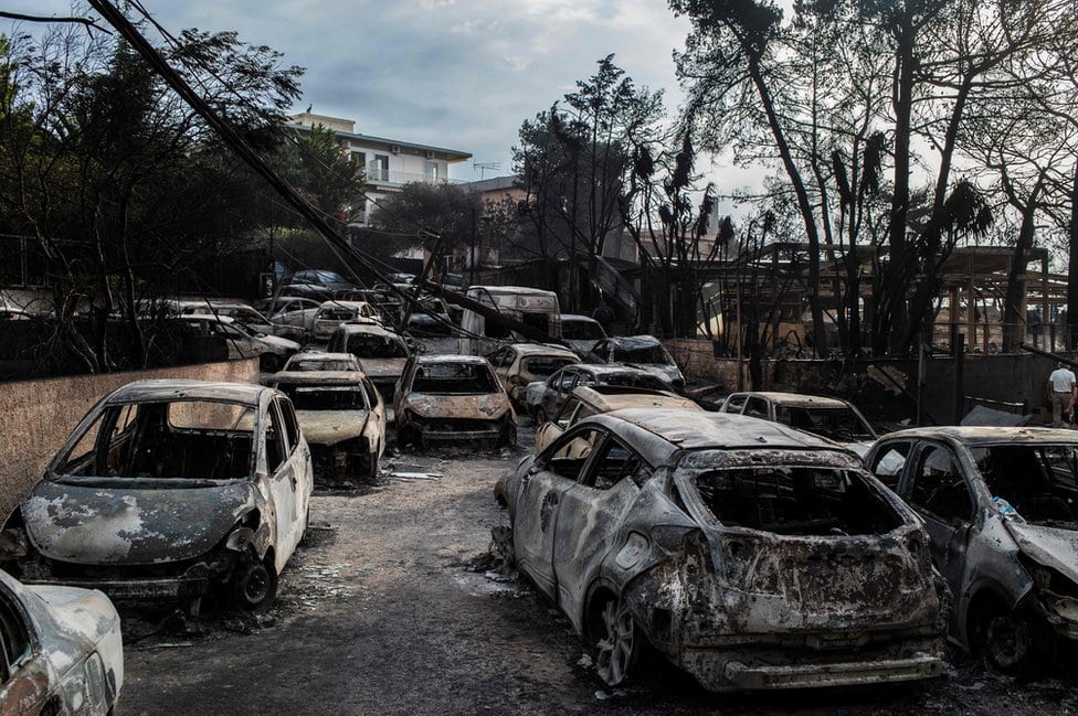 Fotografija pokazuje ulicu punu spaljenih kola u selu Mati.