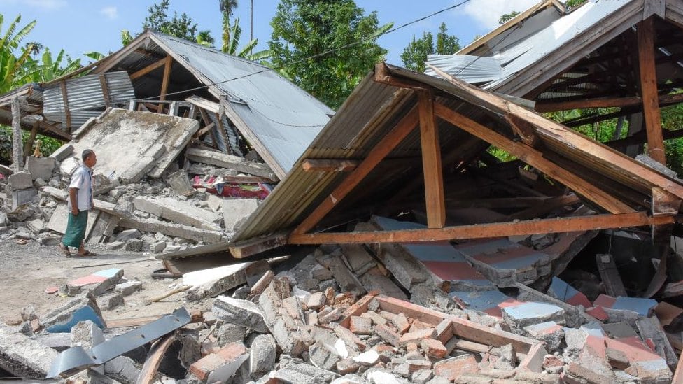 Čovek ispred ostatataka kuće nakon zemljotresa