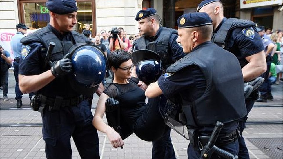Policija nosi učesnicu Hoda za slobodu u rukama