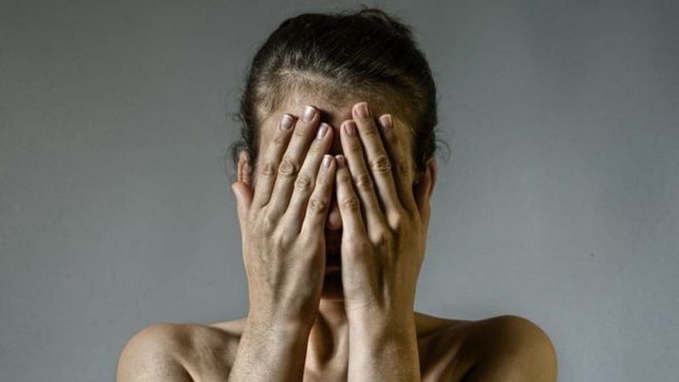 Žena rukama prekriva lice