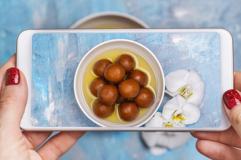 Kako Instagram menja hranu koju jedemo 2 Žena fotografiše porciju gulab jamuna