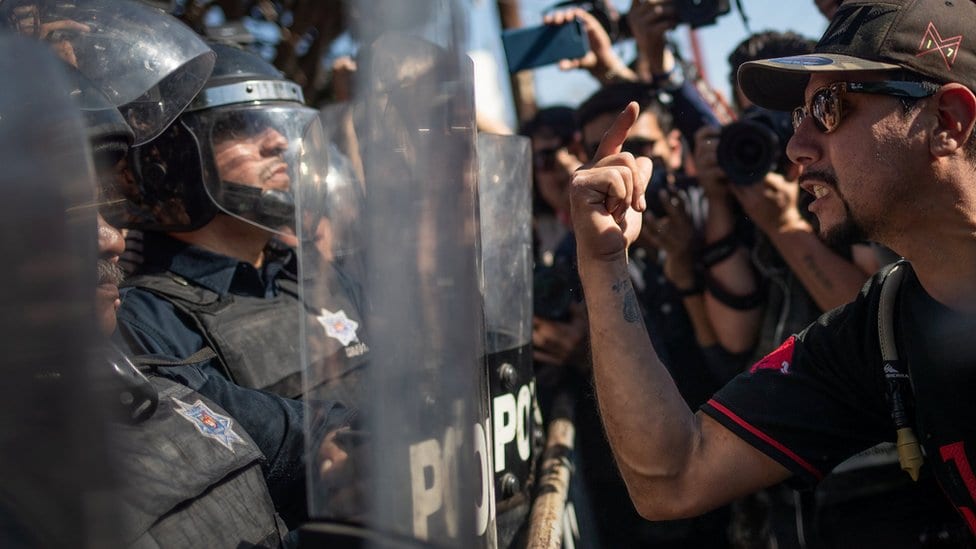 Demonstranti viču na policajce koji obezbeđuju prihvatni centar za izbeglice u Tihuani