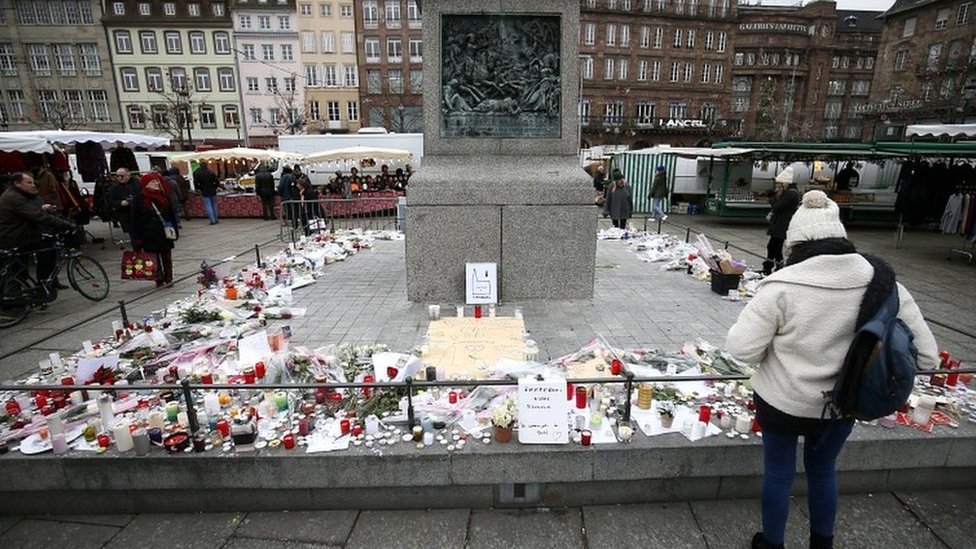 Ljudi gledaju sveće, pisma i cveće na Božićnom vašaru u Strazburu, 14. decembar 2018. godine.