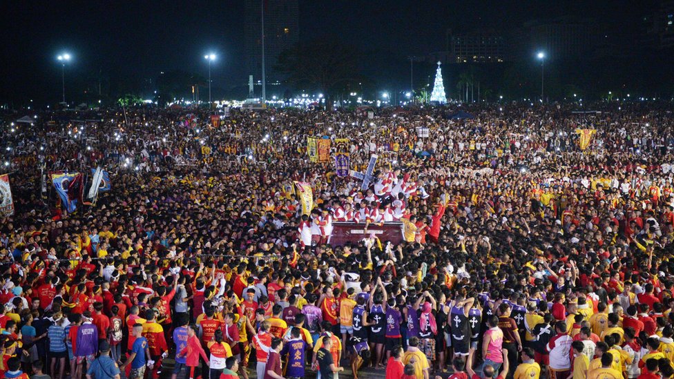 A huge crowd of devotees surrounds the Black Nazarene statue in Manila