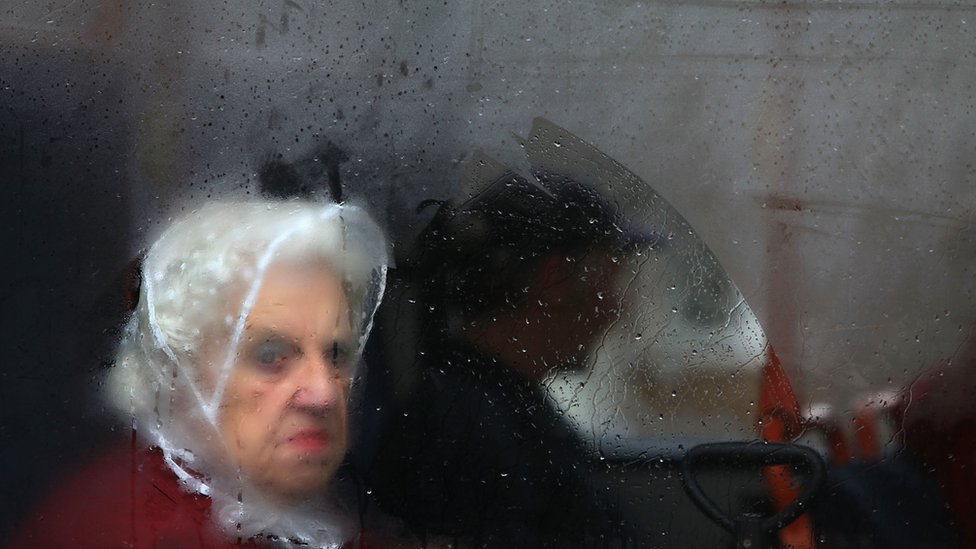 Žena gleda kroz zamagljen prozor
