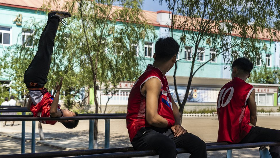 U fotografijama : Odrastanje u Severnoj Koreji 12 Boys practice on the gymnastic parallel bars in their school playground in Hoeryong