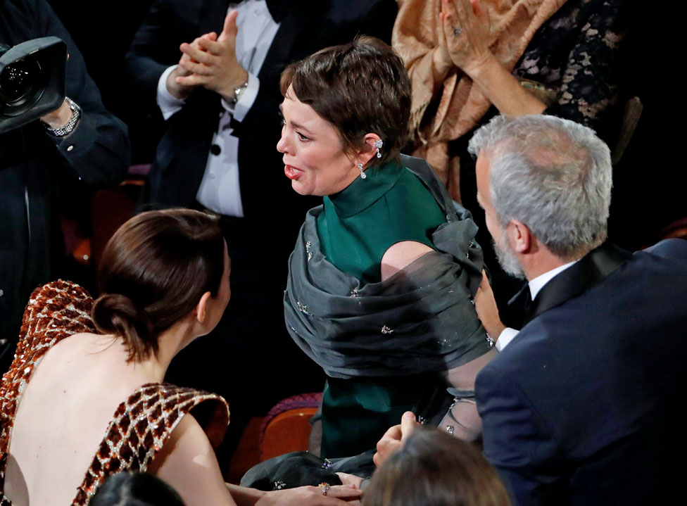 Olivia Colman stands to accept the Best Actress award