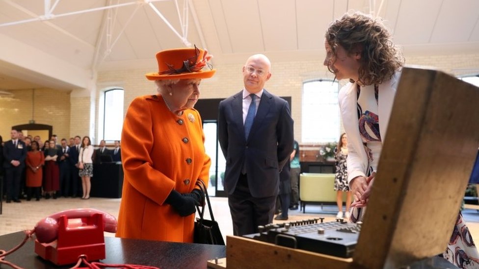 The Queen looking at Enigma machine