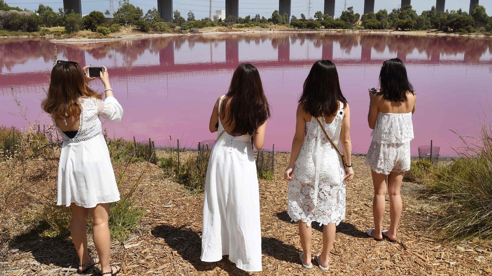 četiri žene u belom ispred jezera