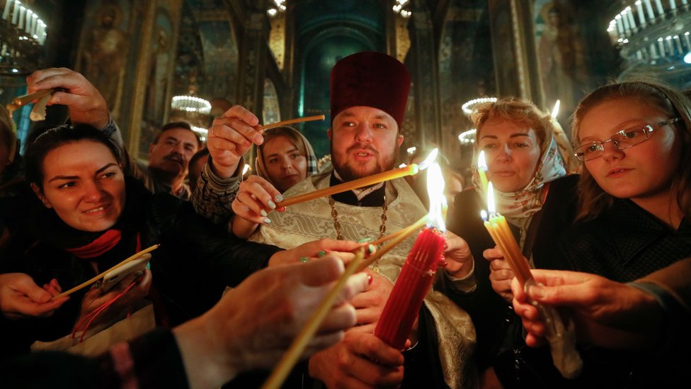 Vernici u Ukrajini pale sveće tokom uskršnje liturgija u Kijevu