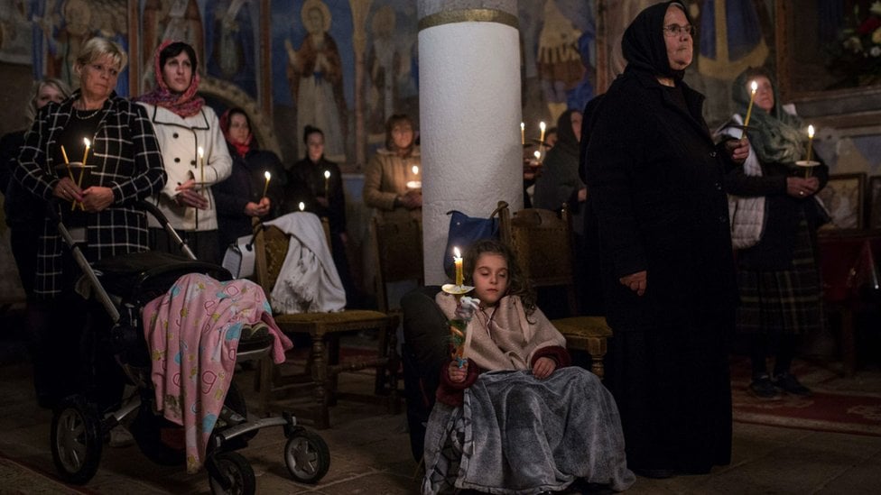 Pravoslavni vernici drže sveće tokom ponoćne uskršnje liturgije u manastiru Sukovo u istočnoj Srbiji