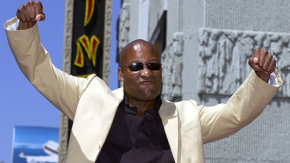 John Singleton poses with arms in the air
