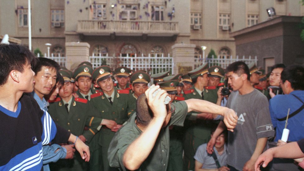 Jedan od studenata baca kamen na ambasadu Amerike u Pekingu, 9. maja 1999. Protesti su izbili u desetak većih gradova u Kini i izvukli desetine hiljada besnih građana na ulice. Kineski državni mediji su podgrejali bes govoreći da je NATO bombardovanje ambasade u Beogradu bio namerni čin agresije.