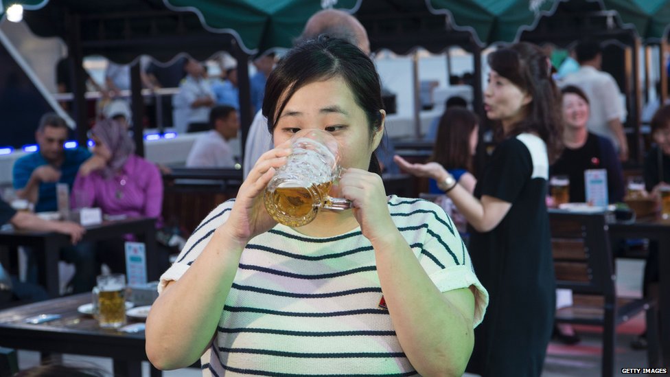 žena pije pivo u Severnoj Koreji