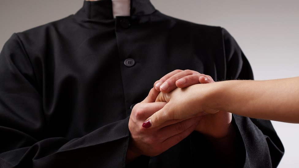 sveštenik drži žensku ruku