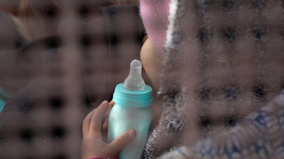 Beba iz Centralne Amerike čeka da je odvedu u pritvor na američko-meksičkoj granici.