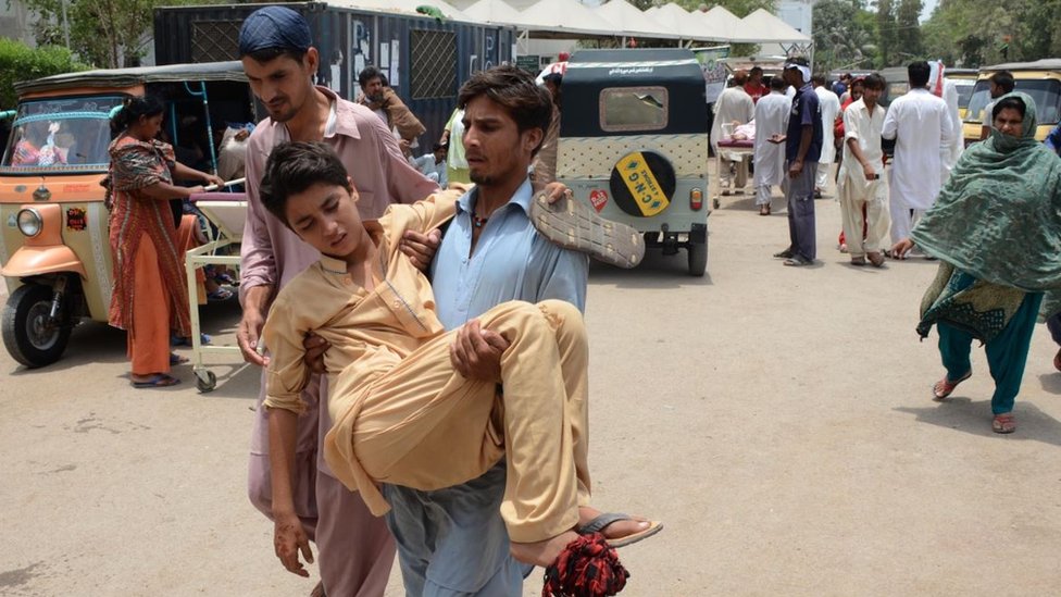 A Pakistani relative carries a heatstroke victim to a hospital in Karachi