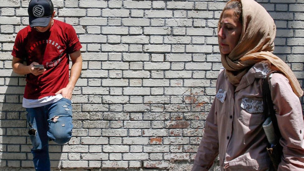 Unutar Irana: Šta Iranci misle o sukobu sa Amerikom 3 A man uses his mobile phone as a woman walks by in Tehran, Iran (8 July 2019)