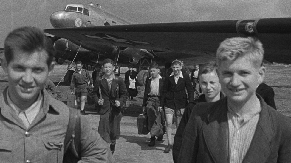 Drugi svetski rat: „Moj deda je preživeo pet nacističkih koncentracionih logora“ 9 Survivors arriving in the UK with an aeroplane in the background