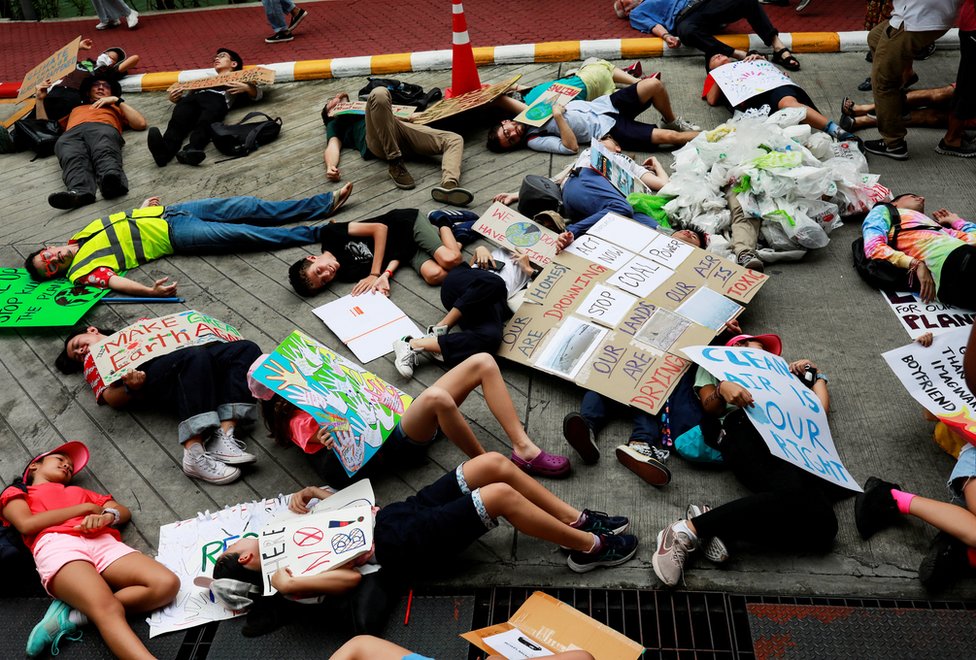 Activists play dead on the floor with banners