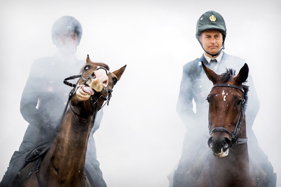 Požari u Amazoniji, protesti i spasavanje migranata - fotografije koje su obeležile nedelju 7 The Dutch Royal Guard guide their horses through clouds of thick smoke and gunfire on the beach of Scheveningen, near The Hague to prepare them for the Prinsjesdag parade. 16 September 2019