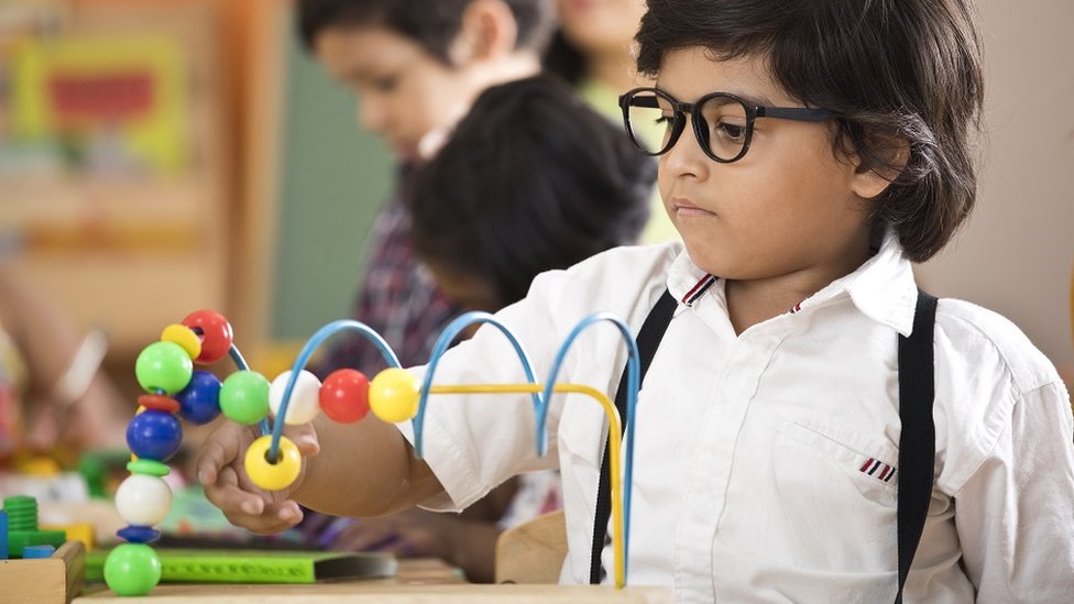 Little boy learning with abacus at preschool