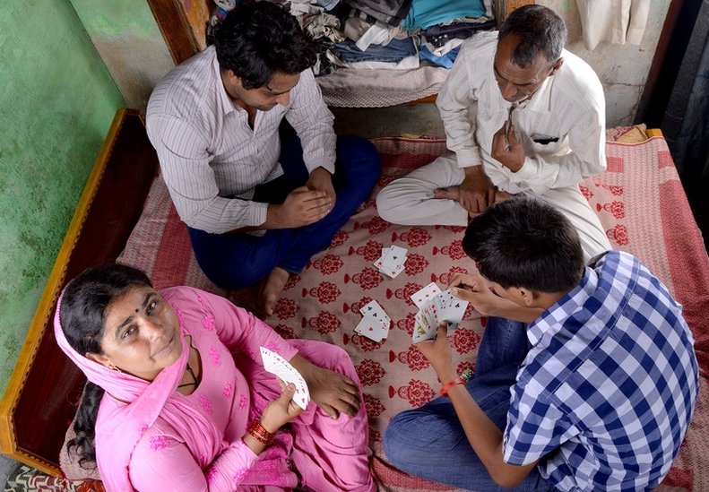 Rural Indian Family Playing Cards at Home on the Bed