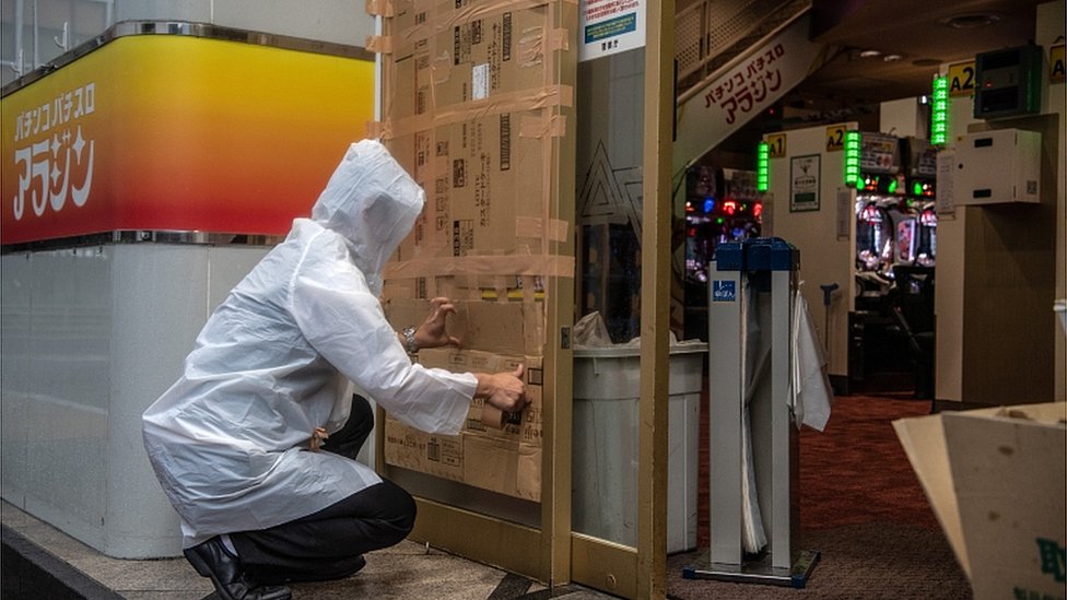 Tajfun Hagibis: Sedam miliona Japanaca mora da se evakuiše 3 A man covers over a doorway to a pachinko parlour ahead of the arrival of Typhoon Hagibis on October 12, 2019 in Tokyo, Japan