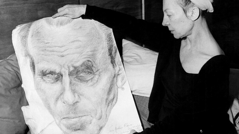 Lucette Destouches holds up a portrait of her husband Louis-Ferdinand Céline in 1969