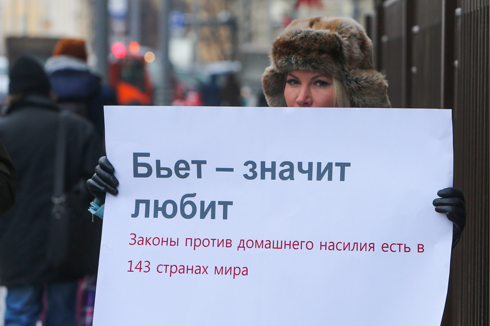 A demonstrator pickets the Russian parliament quoting the saying, "If he beats you it means he loves you" - underneath the placard points out that 143 countries have a law on domestic violence