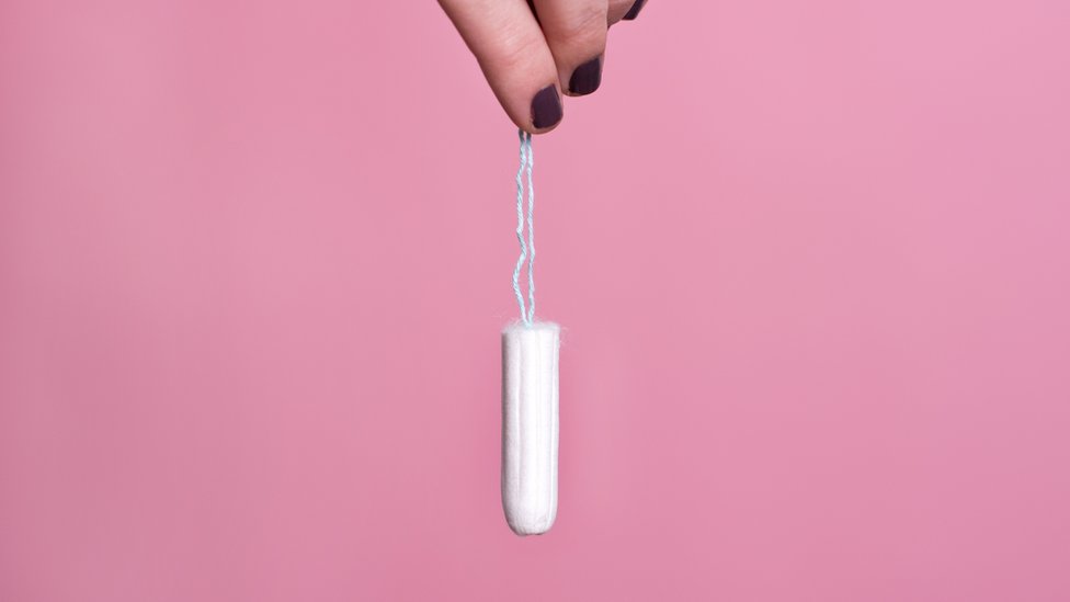Woman's hand holding a clean cotton tampon