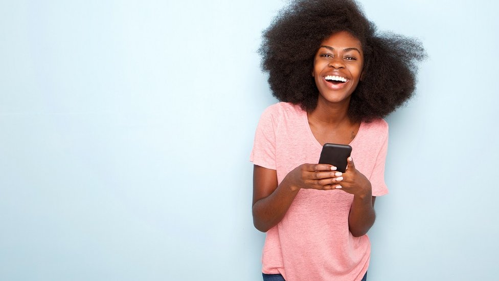 Happy young woman holding smart phone
