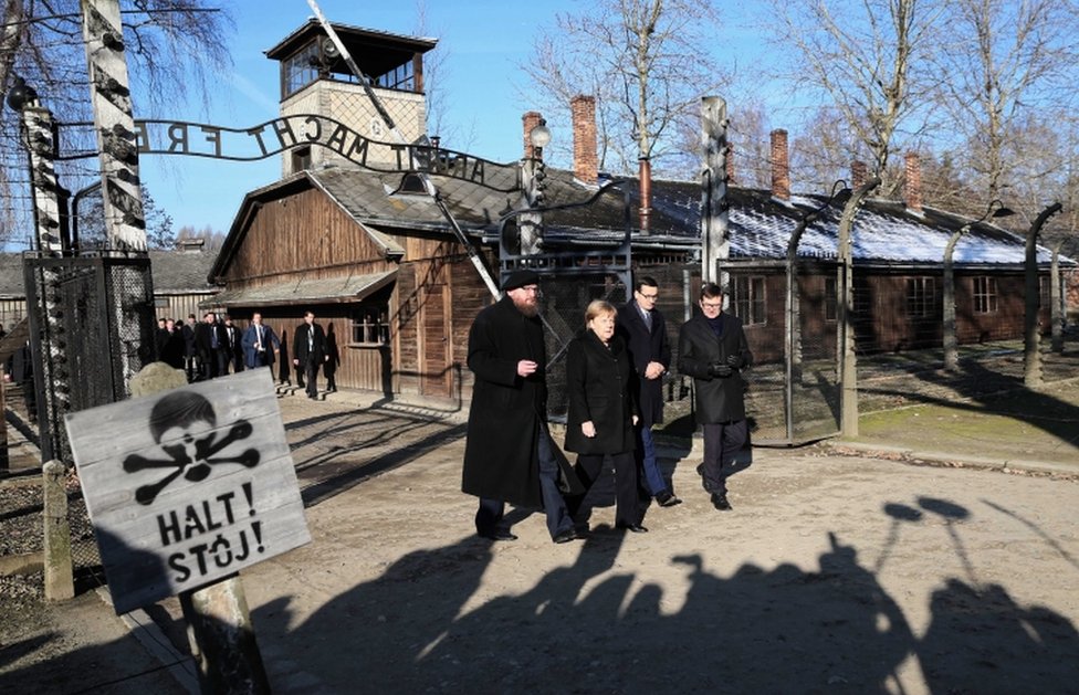 German Chancellor Angela Merkel walks through the gates of the Auschwitz-Birkenau Memorial and Museum, accompanied by Polish Prime Minister Mateusz Morawiecki