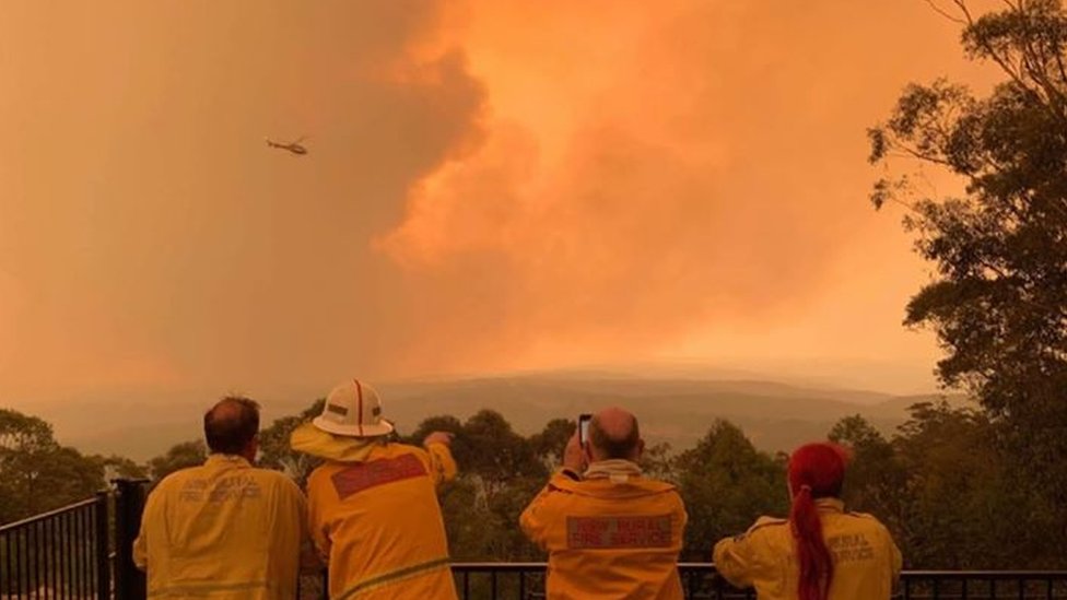 Požari u Australiji: Hiljade dobrovoljaca u borbi protiv plamena 3 Volunteer firefighters watch a blaze in Sydney's south-west