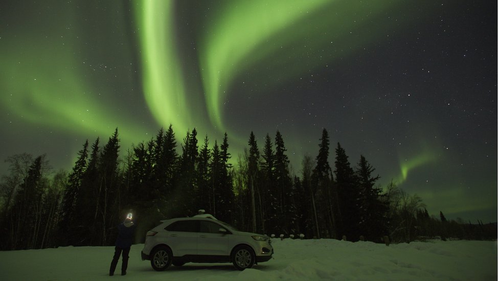 The green light of the Aurora Borealis fills the night sky near North Pole, AK.