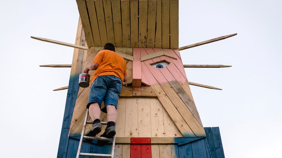 Amerika i Iran: Zašto je zapaljena statua Donalda Trampa u Sloveniji 1 People work on a wooden statue made to resemble US President Donald Trump in the village of Sela pri Kamniku in August 2019