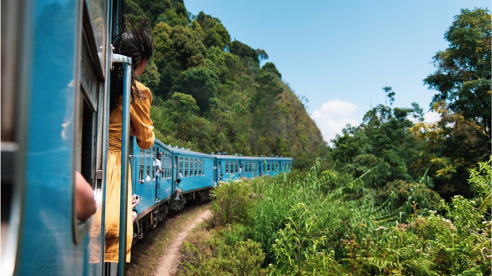 Woman leans outside a train