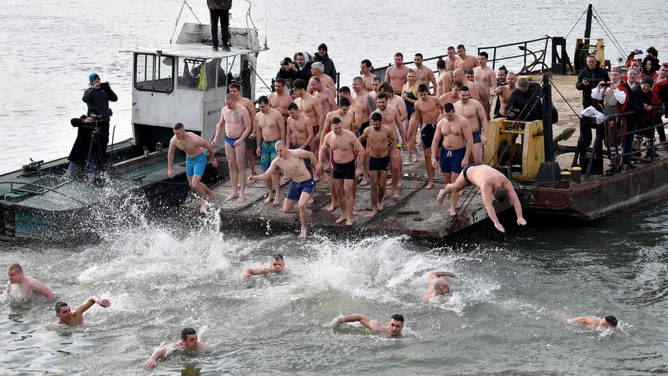 Serbian Orthodox faithfuls jump into the cold water of the Sava river in Belgrade